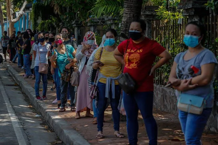 Line of people wearing COVID-19 masks in the Philippines, credit EPA-EFE