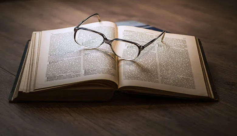 A pair of glasses resting on an open book