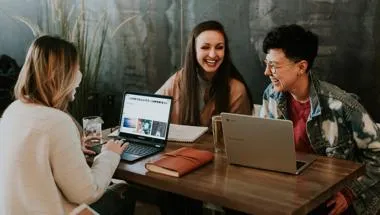 3 people chatting over laptops by brooke-cagle