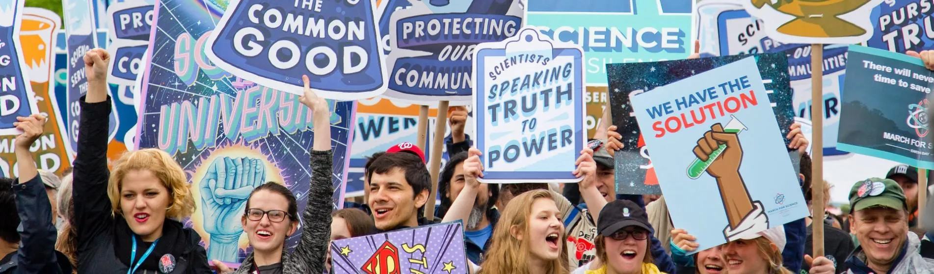 Protesters marching with signs about trusting science and scientists