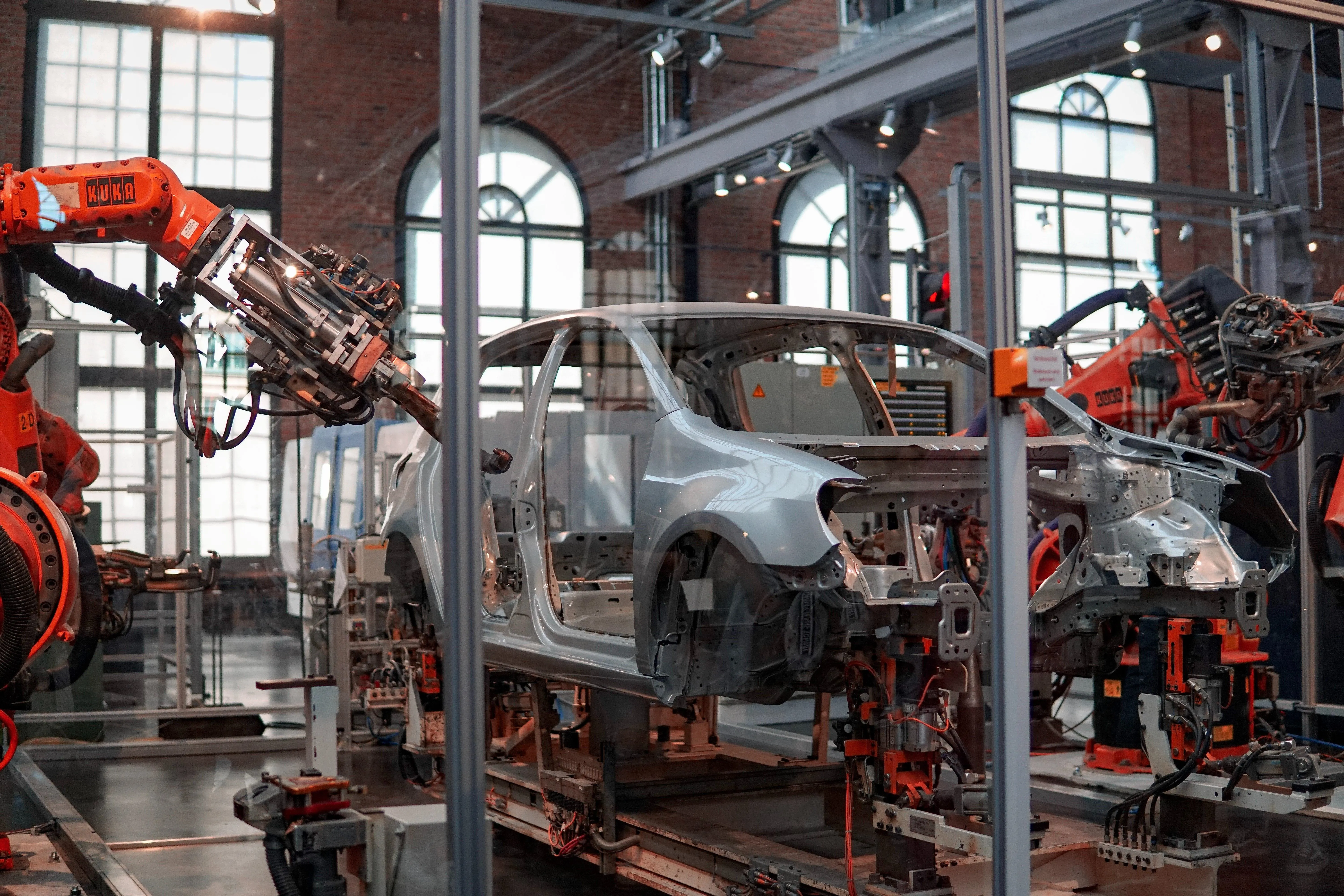 Robotic arms building a car in a factory