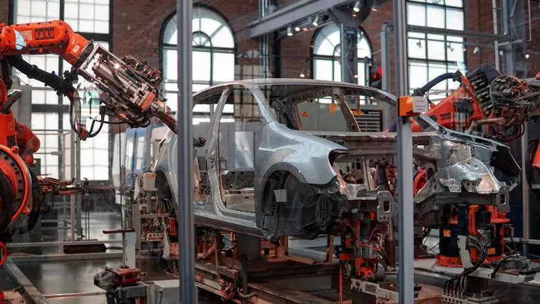 Robotic arms building a car in a factory