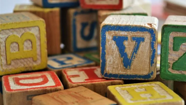 Wooden blocks with letters written on them in different colours.