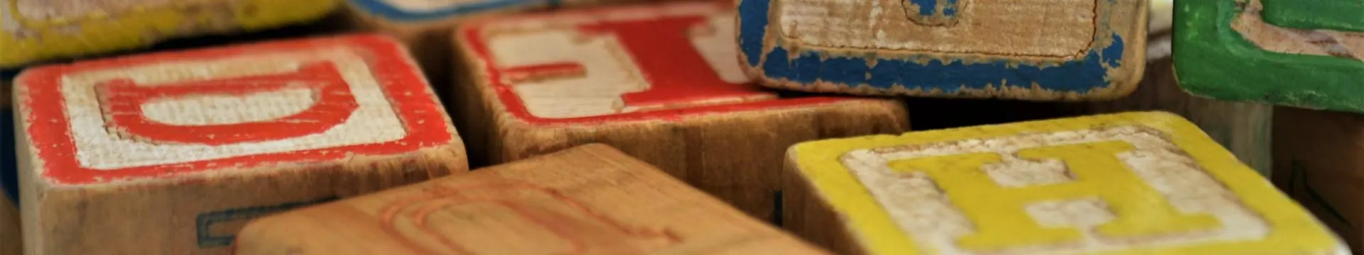 Wooden blocks with letters written on them in different colours.