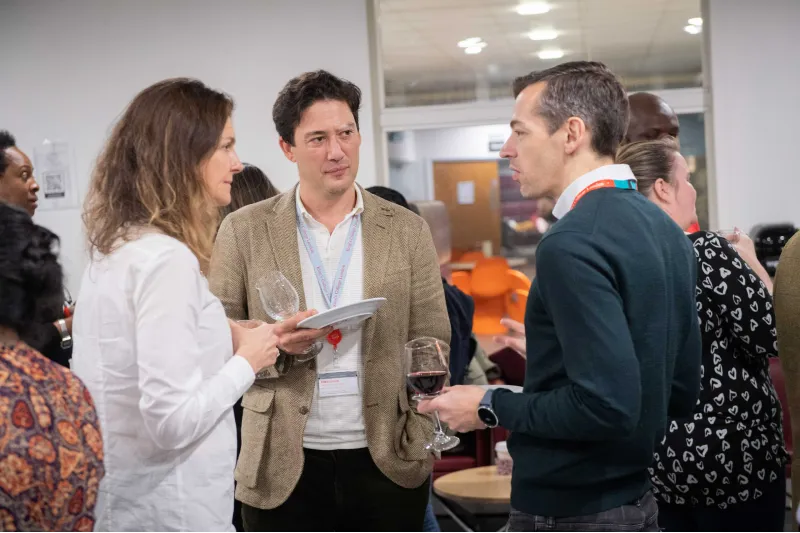 Melissa Glackin discussing with two men (one current and one past student) at the Celebration event of the MA in STEM Education, in November 2021 at King's College London.