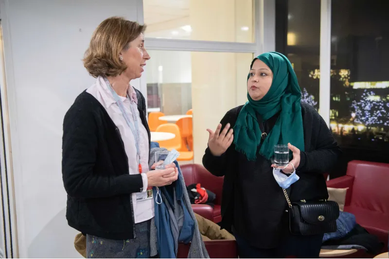 Two women, one wearing a headscarf, talking at the Celebration event of the MA in STEM Education, in November 2021 at King's College London.