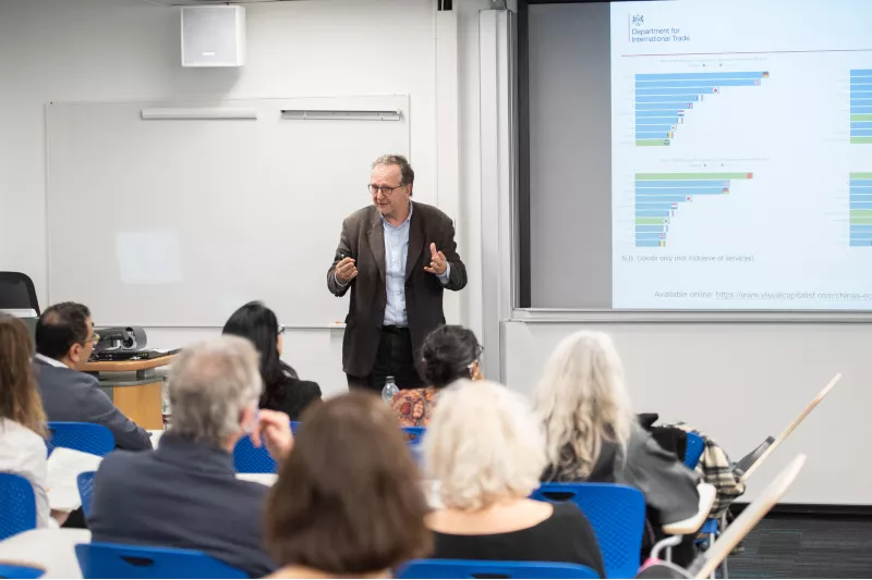 Photo of Dr Mike Short CBE giving a presentation in front of a small audience at the Celebration event of the MA in STEM Education, in November 2021 at King's College London.