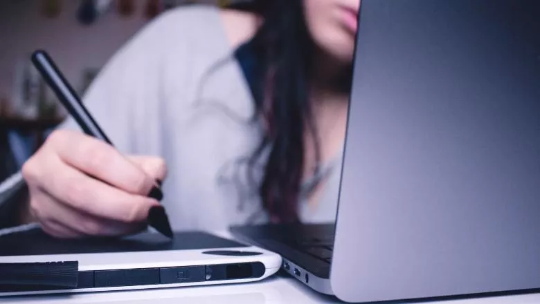 Girl hand on pad next to laptop - josefa-ndiaz-780x440jpg