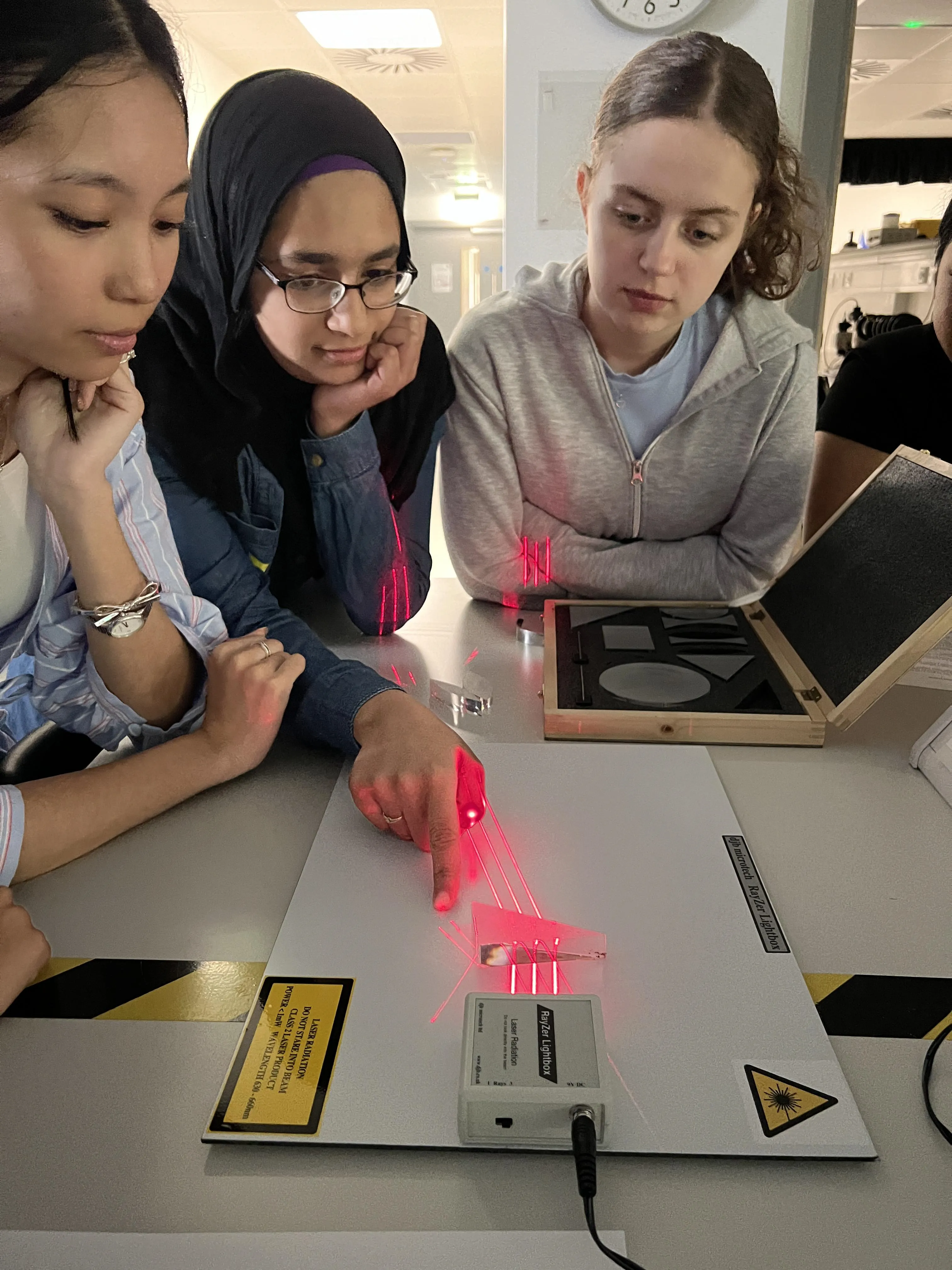 three girls conducting physics experiment