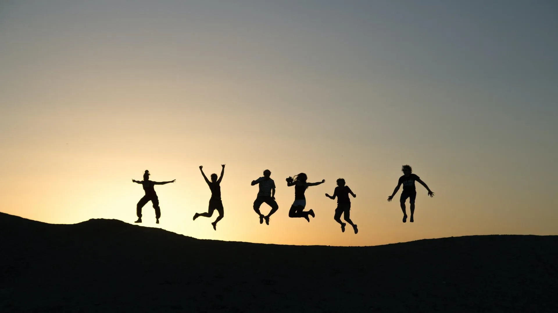 Young people jumping against sunset - timon-studler 2000x1125