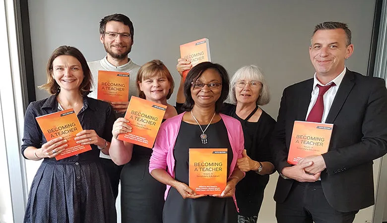 Staff holding copies of 'Becoming a Teacher'