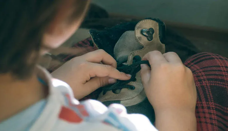 A child tying shoelaces