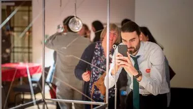 A man taking a photo of science apparatus at an event