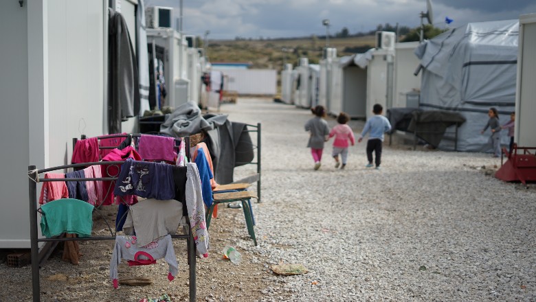 3 children walking in refugee camp - by julie ricard