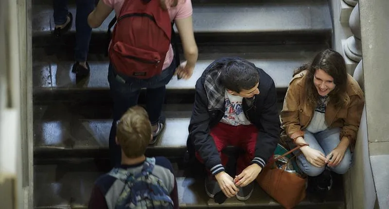 Students sitting on the stairs in the King's Building