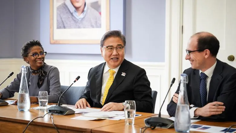 Three people sat at table in panel discussion