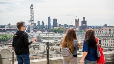 Three students looking across London towards Parliament