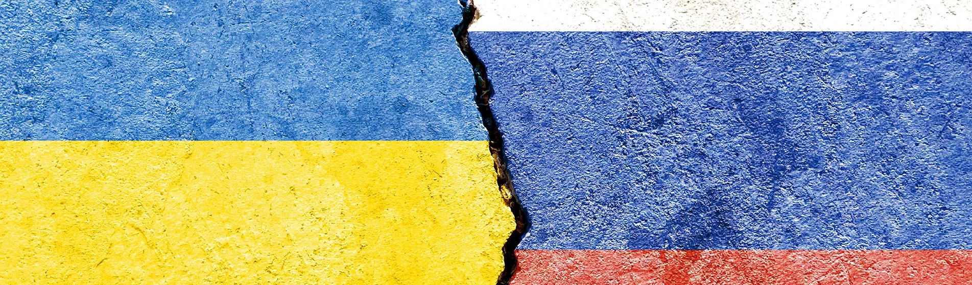 ukraine and russia's flags painted on broken concrete