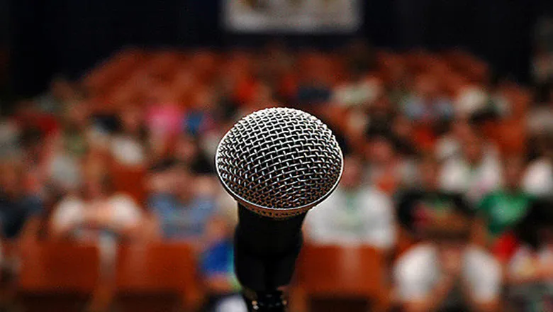 A microphone contrasted against an audience