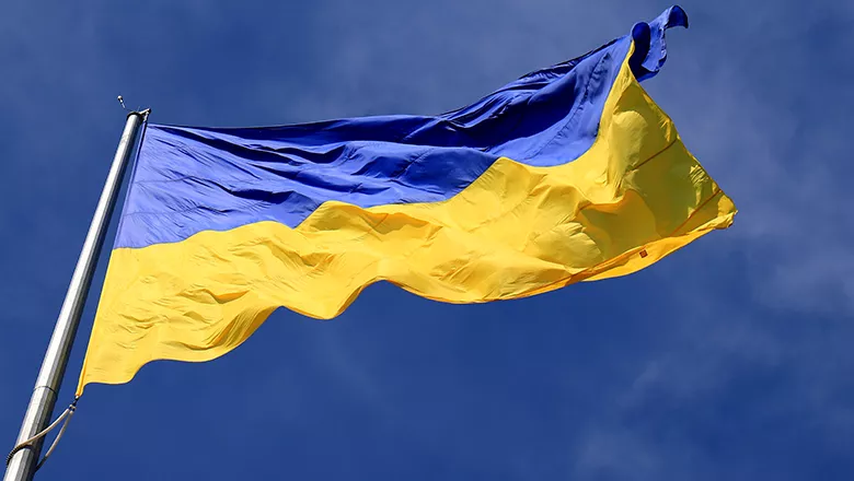 Ukraine flag fluttering against a blue sky