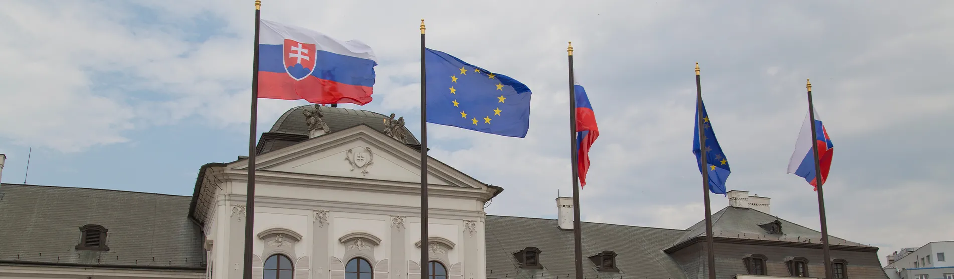 Slovakian and EU flags outside the Parliament building in Bratislava