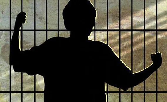 Drawn image of a shadow of a child behind prison bars