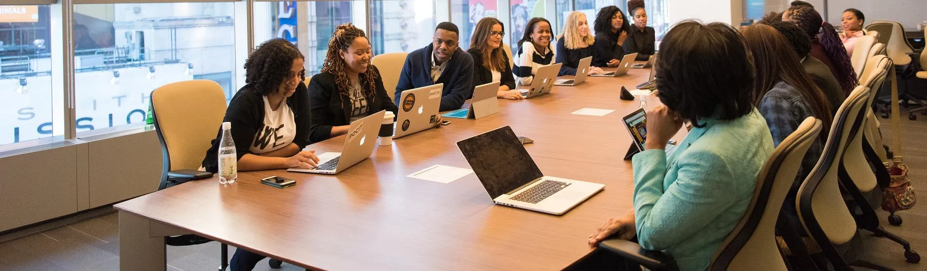 A diverse group of women and men around a boardroom table