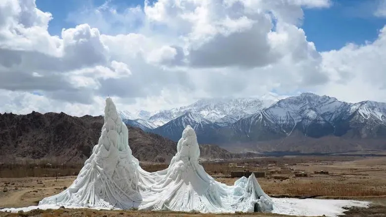 small ice peaks on a grassland with mountains in the background