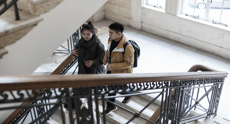 Two students on the staircase at Bush House