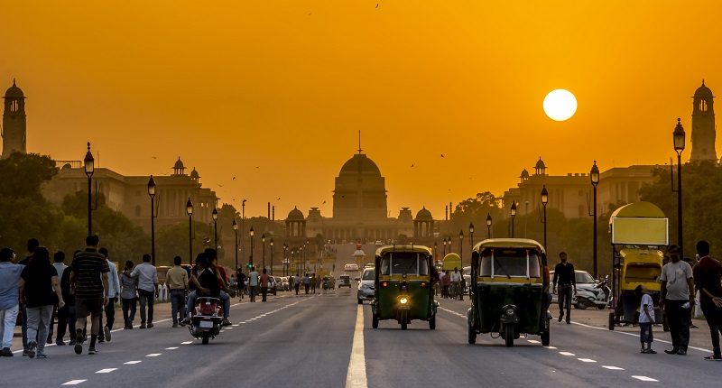 Vehicles in India against an orange sky