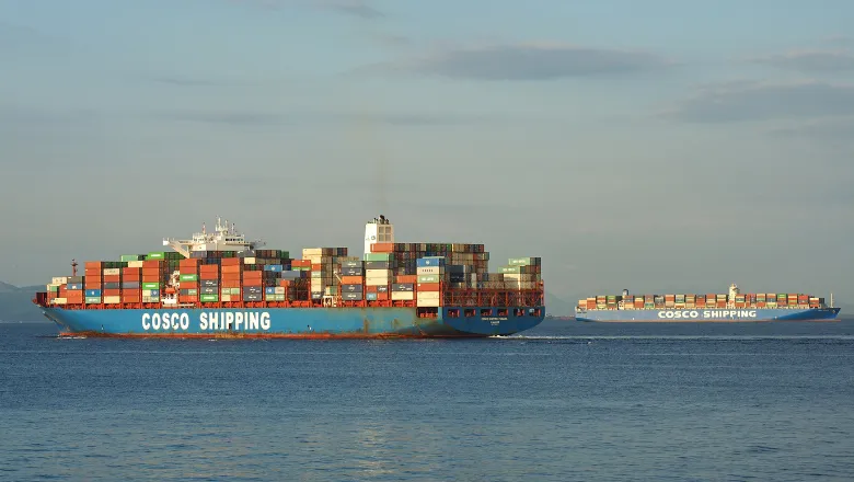 two large cargo ships on the sea with the branding 'COSCO SHIPPING'