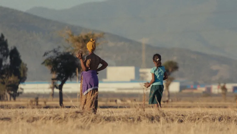 Farmer Workinesh Chala and her daughter Rehoboth standing in the fields of Dibdibbe Village, looking out towards the Eastern Industry Park, Oromia region, Ethiopia