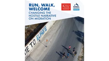 Runners alongside "Welcome to Europe" graffiti