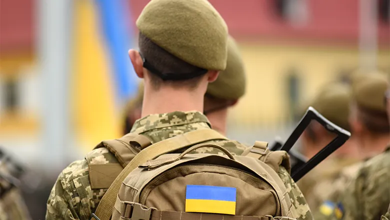 Ukrainian soldier wearing backpack with Ukrainian flag 