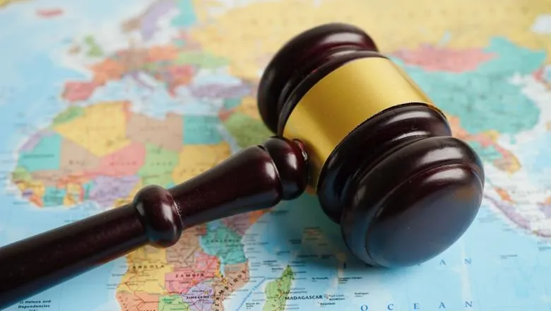 A gavel lying on a world map with Africa, Europe and Asia visible