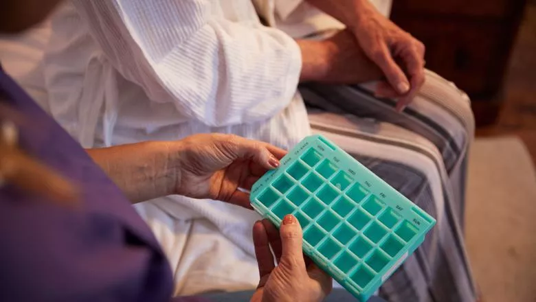 Nurse Helping Senior Woman To Organize Medication On Home Visit