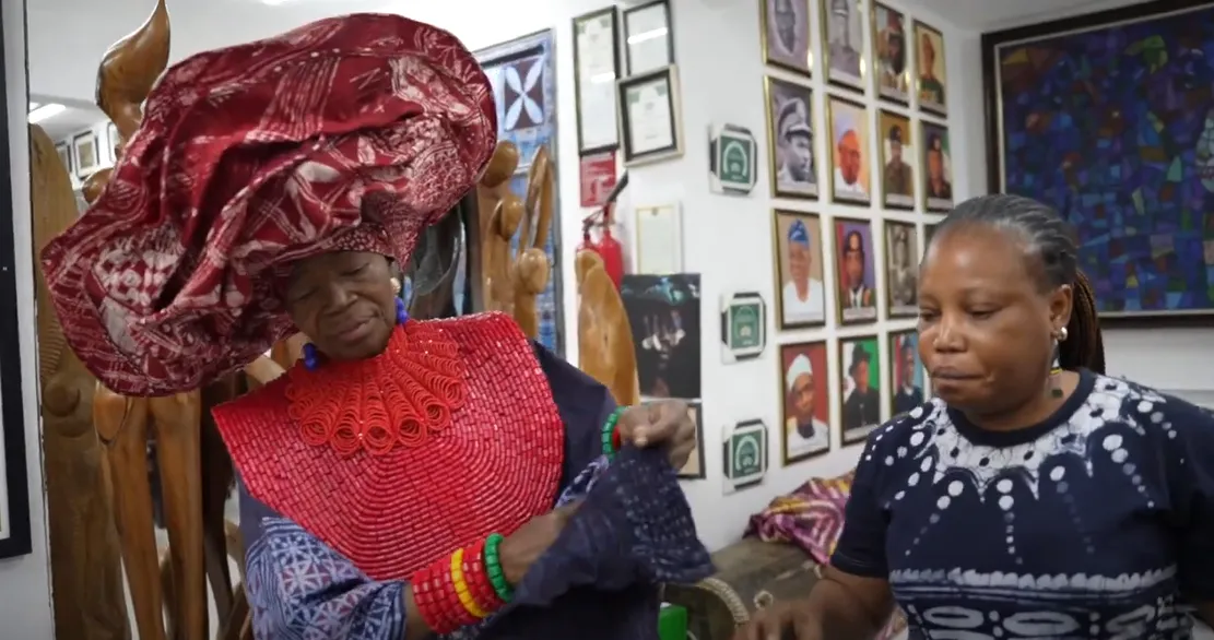 Textile artist Chief Dr Nike Davies-Okundaye inspects a cloth produced in the traditional Yoruba textile practice known as Adire.