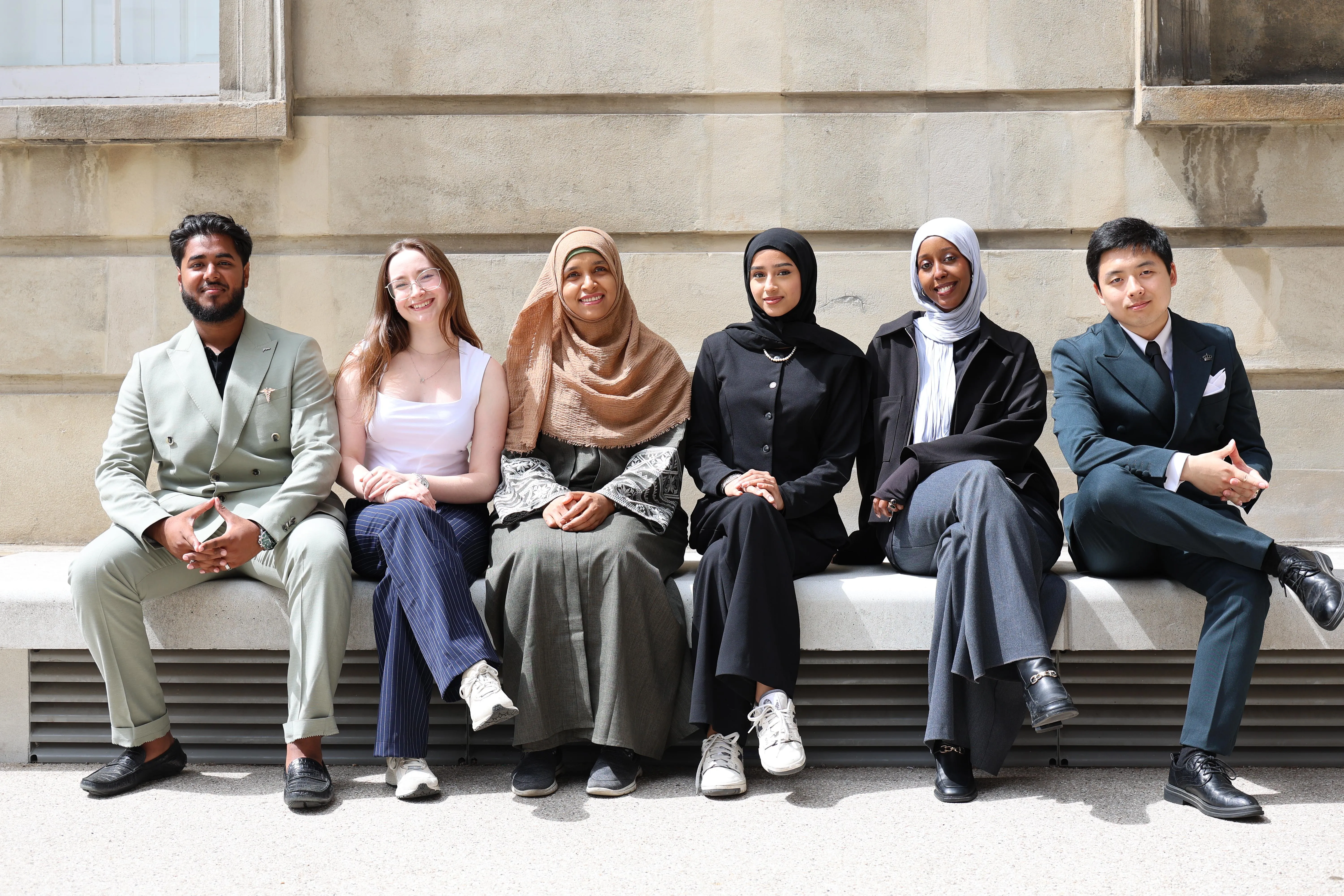 Six King's students sitting on a bench.