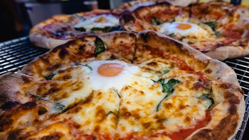 Close up from King's Food outlet of three Florentine pizzas with spinach and fried egg