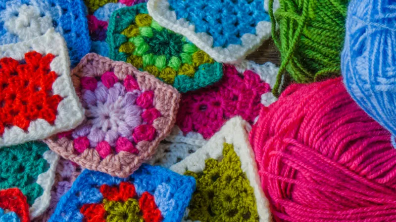 Crochet 'granny squares' and yarn.
