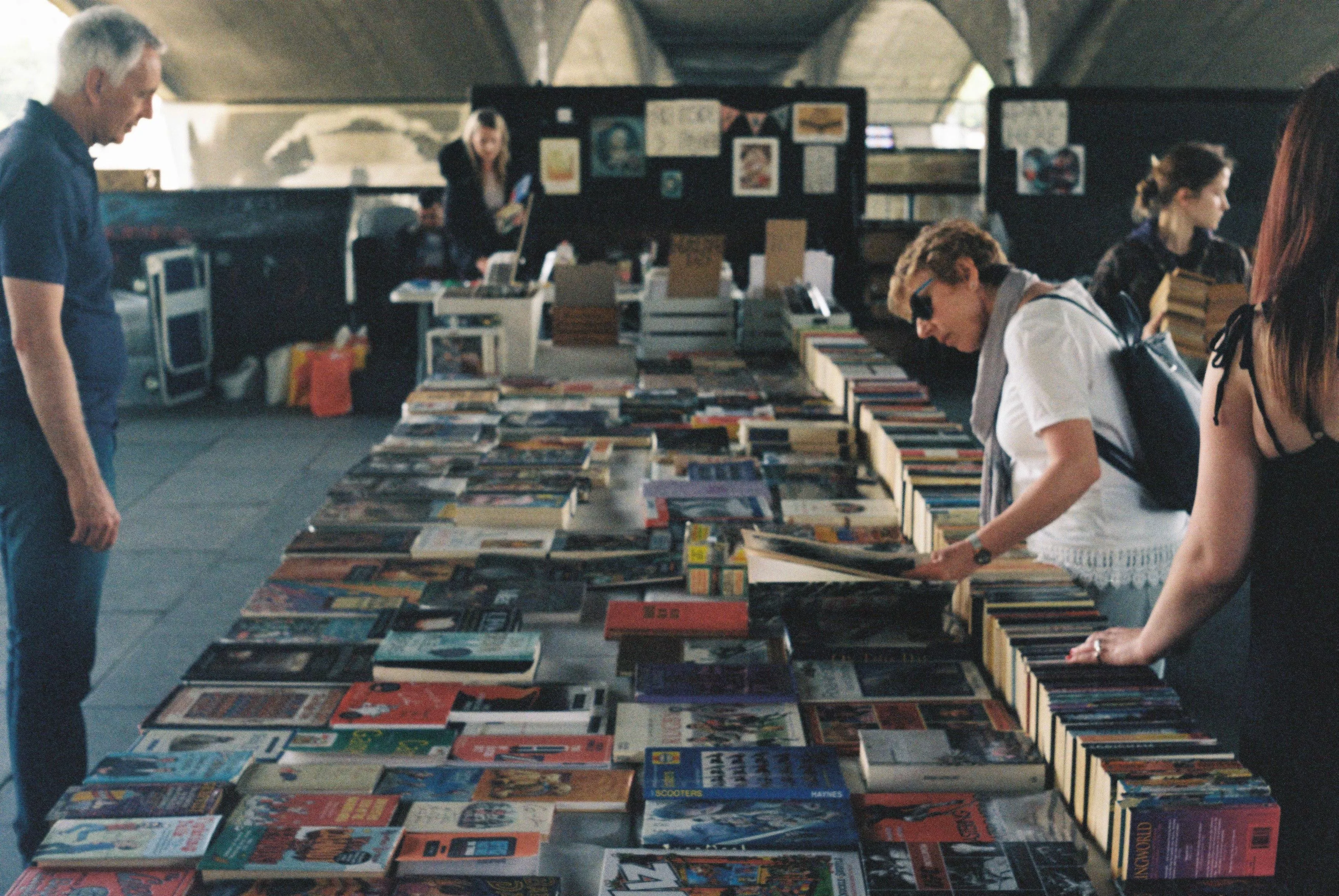 A table filled with second-hand books under Waterloo Bridge