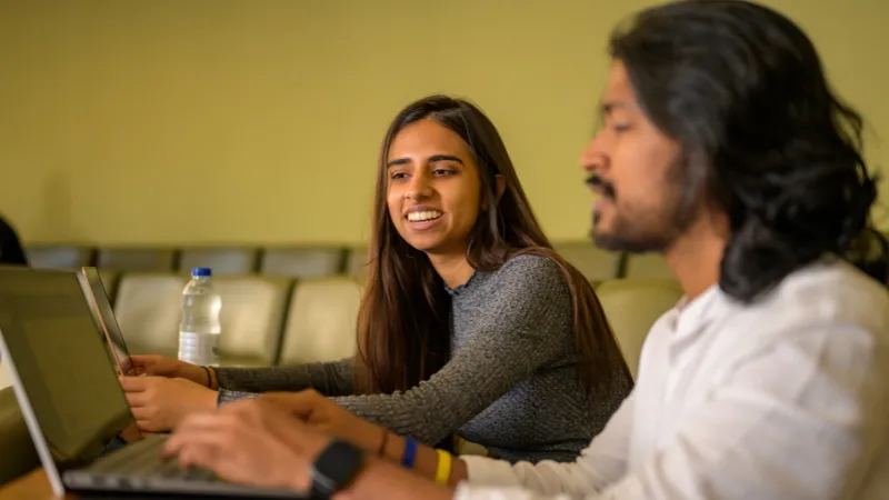 Two people looking at a laptop screen