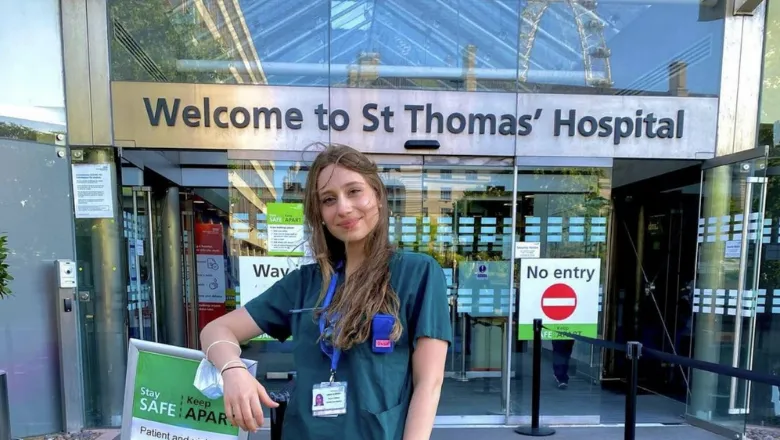 A student in green scrubs outside St Thomas' Hosptial