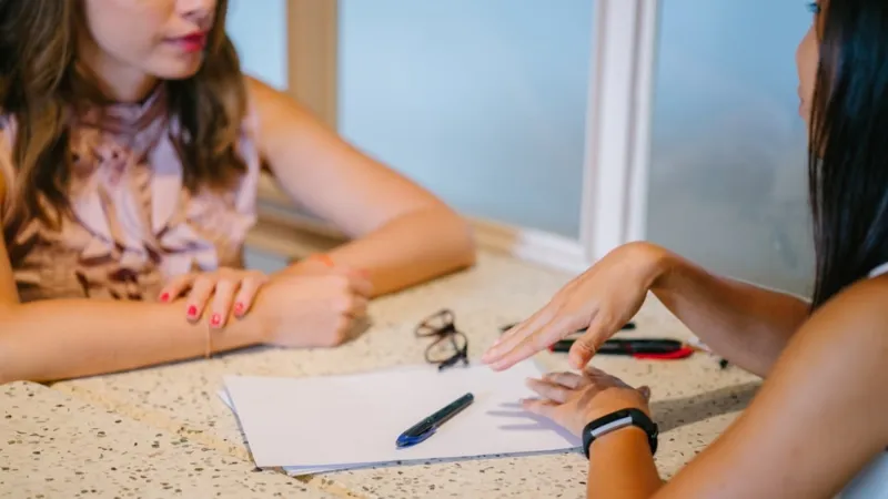 Two students discussing at a table.