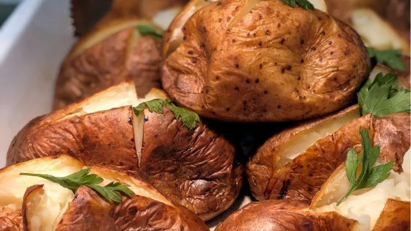 Image: A tray of jacket potatoes cut and ready to be served