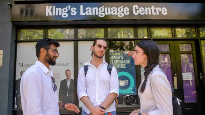 Three students stood outside the Language Centre talking