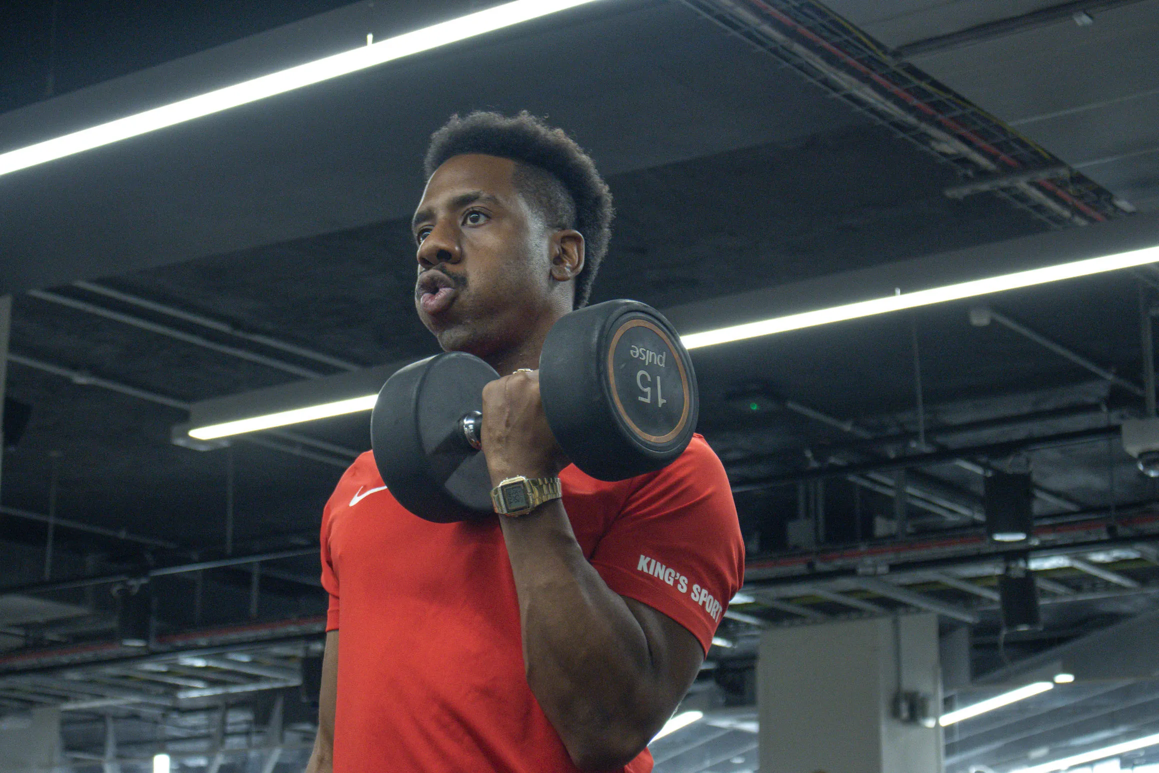 Personal trainer Arral Smith breathes lifts a 15kg dumbell