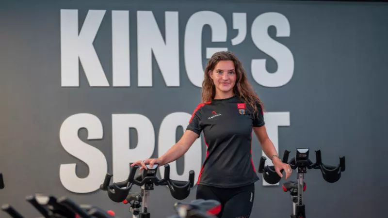 An image of a King's Sport & Wellness trainer in front of spin bikes