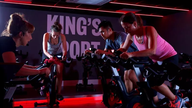 Four people participating in an exercise bike class