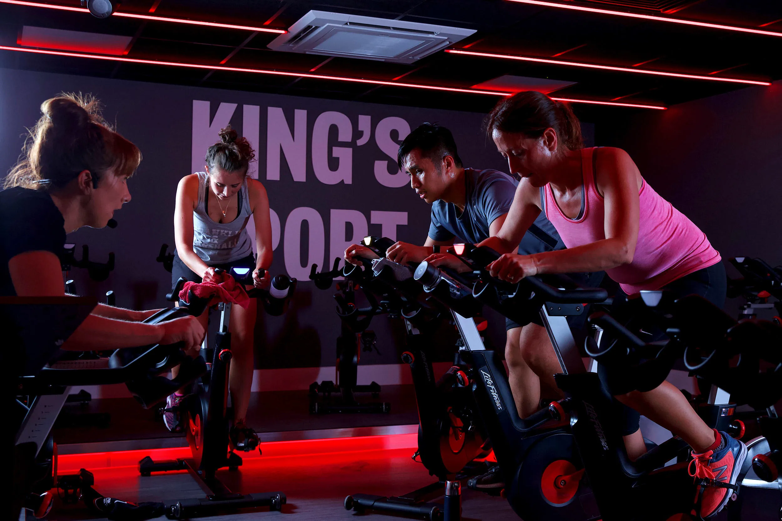 Four people participating in an exercise bike class